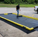 A man rolling out track guards on a ProFlex Foam Wall Berm