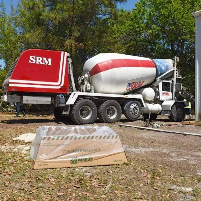 A concrete washout berm economy model with a cement truck in the background